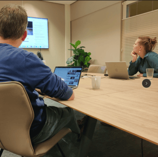 Twee mensen aan tafel bij Hartwig tijdens een online meeting